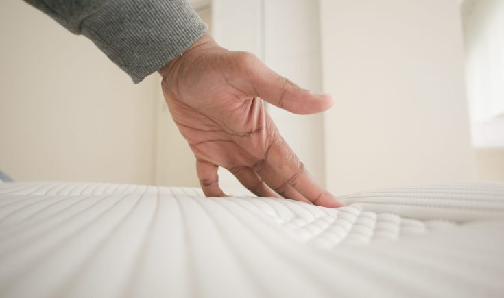 hand-touching-pressing-orthopedic-mattress-bed